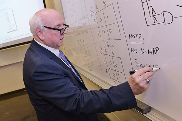 Pre-Engineering Faculty Pre-Engineering Program Directory, James O'Connor, writing out equations on a whiteboard