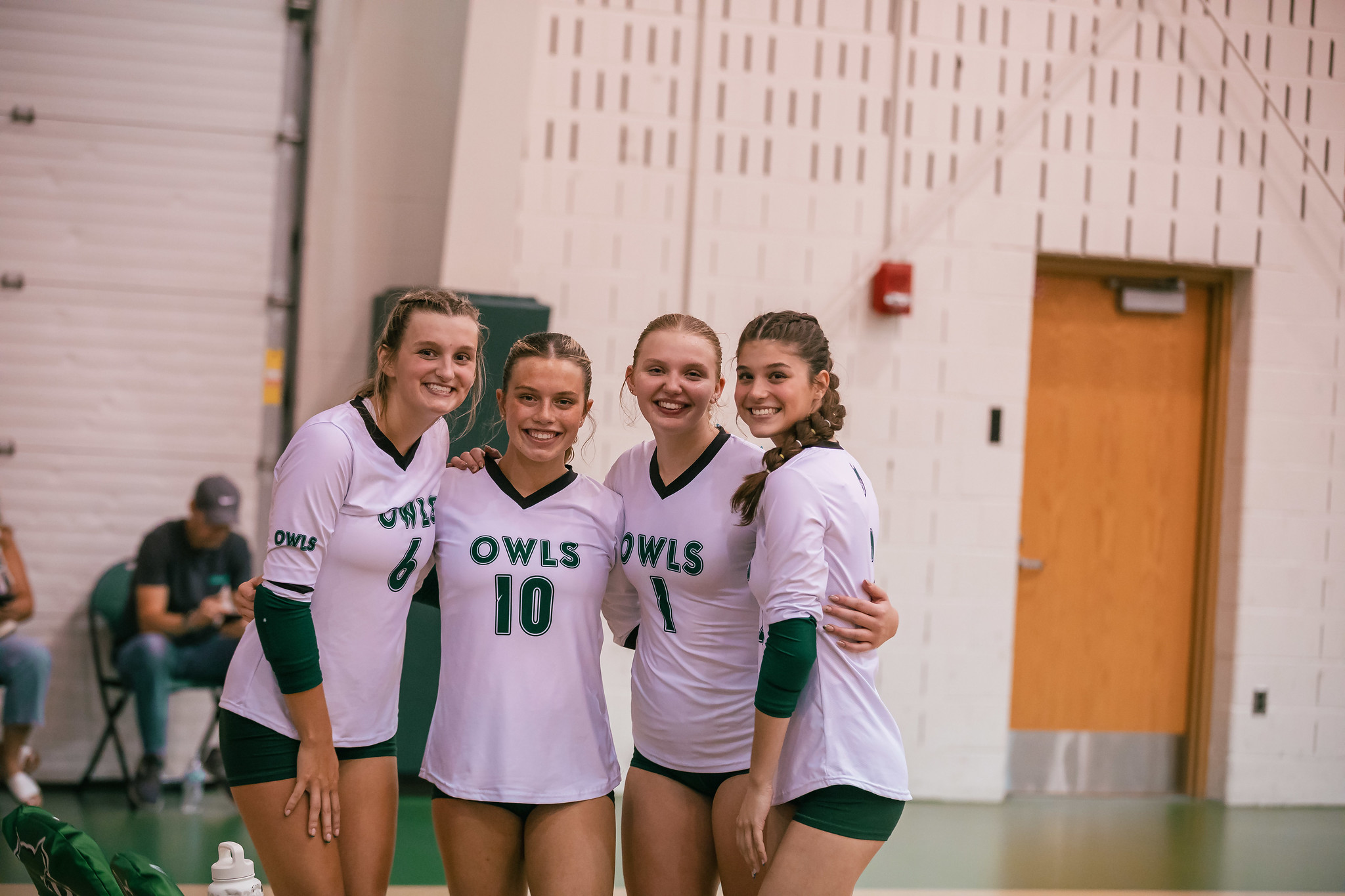 OCC Owls volleyball players pose and smile in uniform