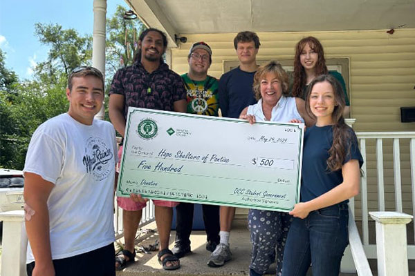 Student government students holding a big check