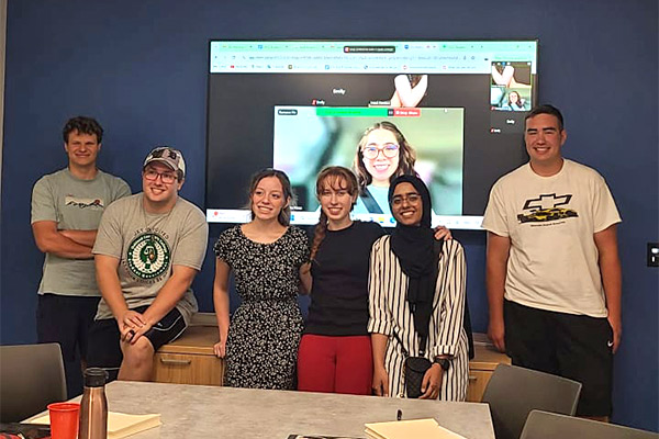 Student government students standing in front of a screen