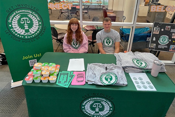 Two students sitting at a student government table.